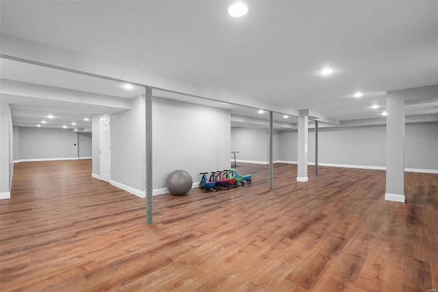 finished below grade area featuring recessed lighting, baseboards, and wood finished floors