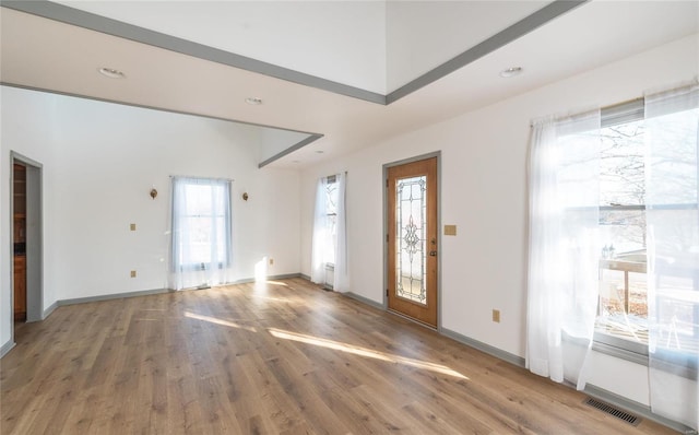 entrance foyer featuring light wood-style flooring, visible vents, and plenty of natural light
