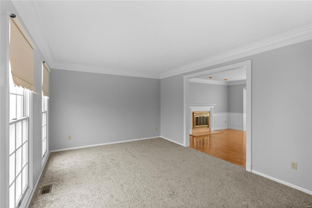 unfurnished living room with crown molding and carpet flooring