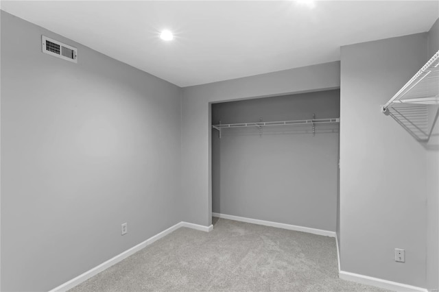 unfurnished bedroom with light colored carpet and a closet