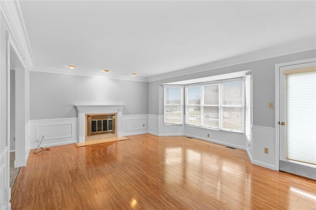 unfurnished living room featuring ornamental molding and light hardwood / wood-style flooring