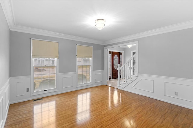 unfurnished room featuring ornamental molding and light hardwood / wood-style flooring