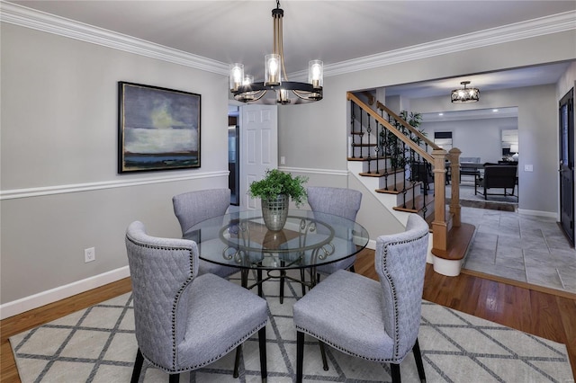 dining area with crown molding, a notable chandelier, and light hardwood / wood-style flooring