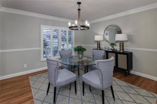 dining area featuring hardwood / wood-style flooring, crown molding, and a notable chandelier