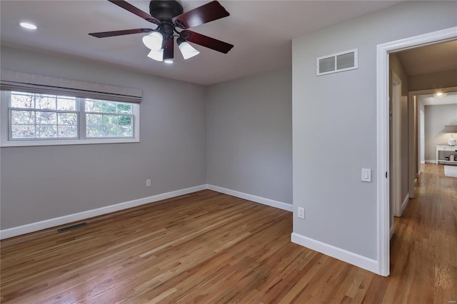 empty room with ceiling fan and light wood-type flooring