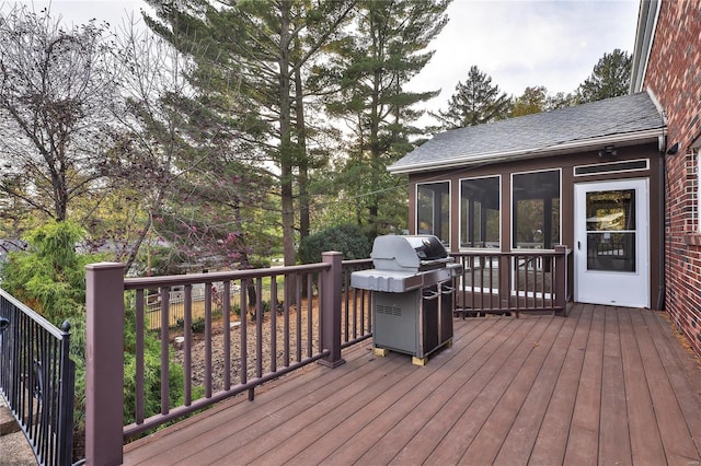 wooden terrace with a grill and a sunroom