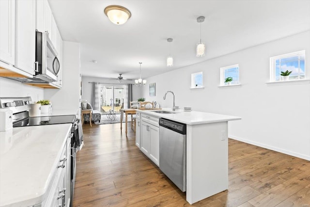 kitchen with hanging light fixtures, an island with sink, and appliances with stainless steel finishes