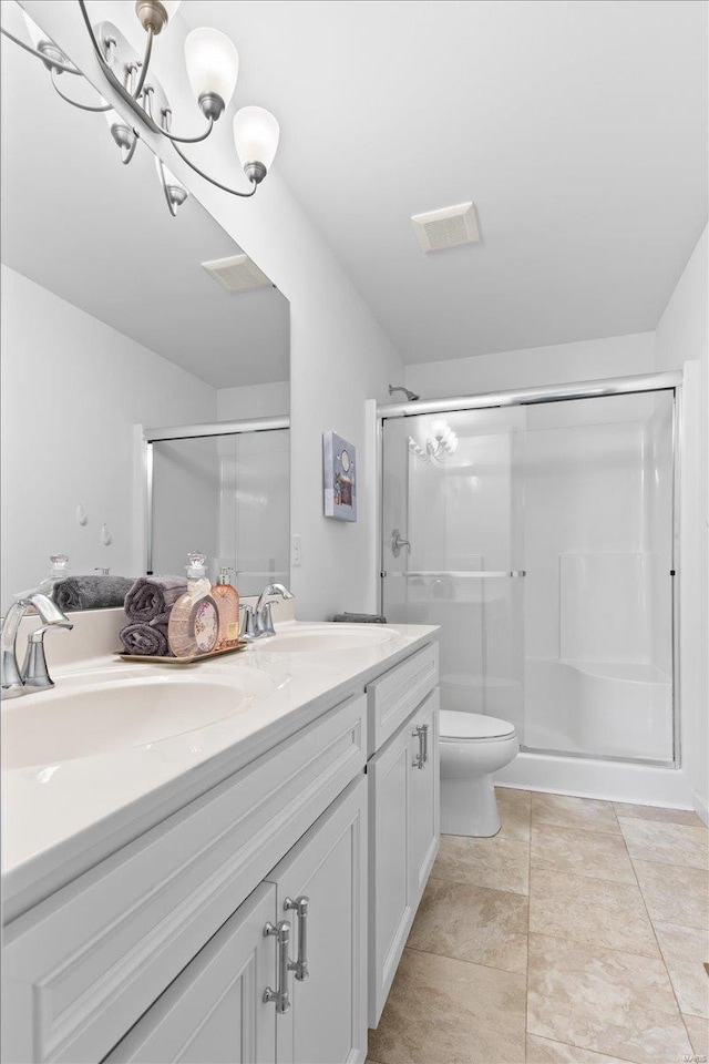 bathroom featuring a shower with shower door, tile patterned flooring, vanity, a notable chandelier, and toilet