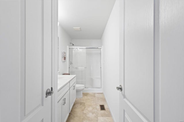 bathroom featuring vanity, a shower with shower door, and toilet