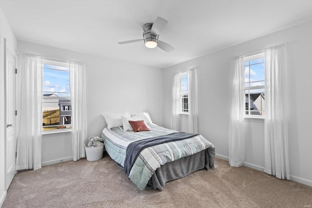 carpeted bedroom with multiple windows and ceiling fan