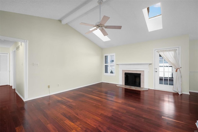 unfurnished living room with beam ceiling, a healthy amount of sunlight, a fireplace, and a skylight