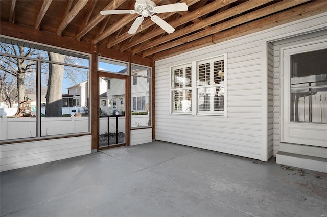 unfurnished sunroom featuring ceiling fan