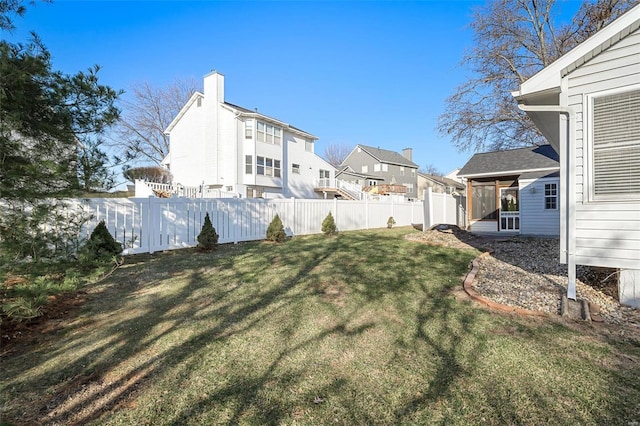 view of yard with fence, a residential view, and a sunroom