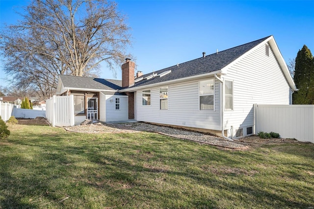 rear view of house with fence, a chimney, a lawn, and a sunroom