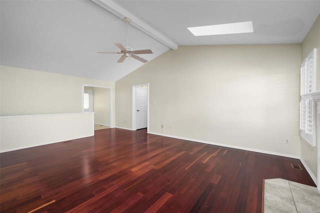 empty room with visible vents, lofted ceiling with skylight, baseboards, and wood finished floors