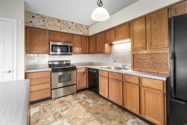 kitchen featuring black appliances, a sink, brown cabinetry, light countertops, and decorative backsplash