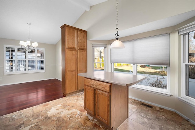 kitchen featuring lofted ceiling with beams, baseboards, visible vents, and a wealth of natural light