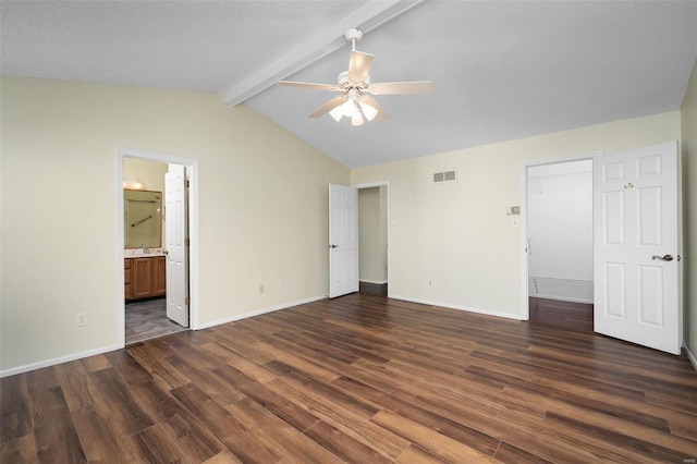 unfurnished bedroom with visible vents, baseboards, vaulted ceiling with beams, and dark wood-style flooring