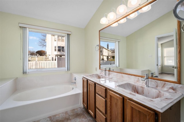 bathroom with a sink, a bath, double vanity, and vaulted ceiling