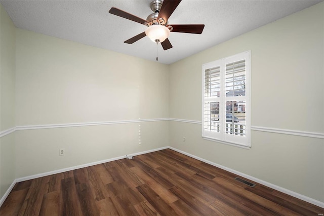 empty room with visible vents, baseboards, a textured ceiling, and wood finished floors