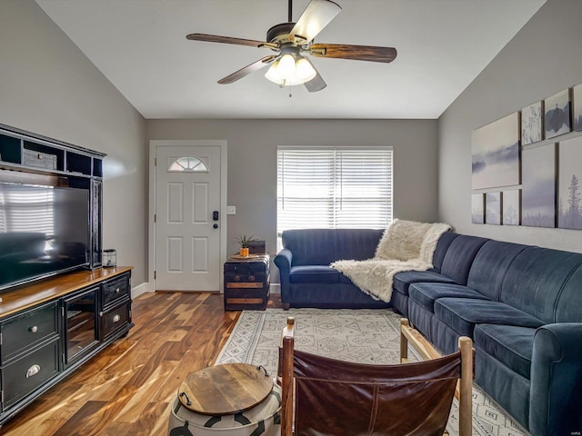 living room featuring vaulted ceiling, wood finished floors, baseboards, and ceiling fan