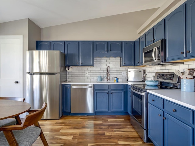 kitchen featuring blue cabinets, appliances with stainless steel finishes, and a sink