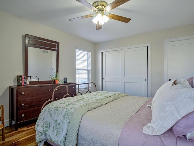 bedroom featuring a closet, visible vents, a ceiling fan, and wood finished floors