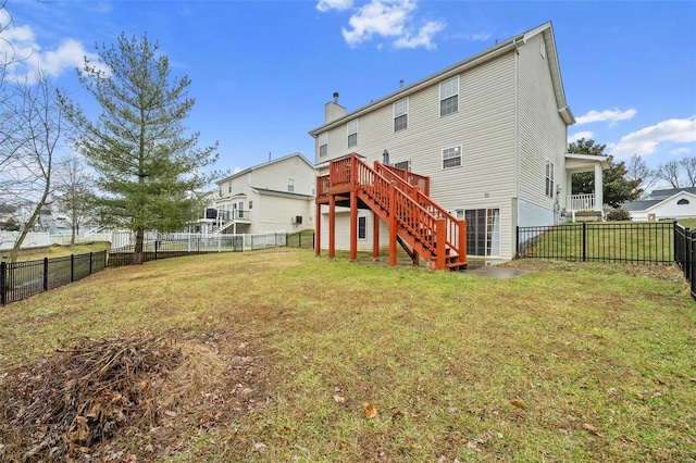 rear view of house with a lawn and a deck