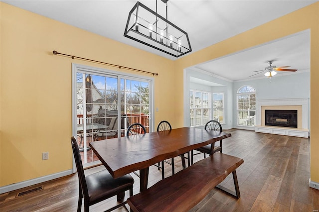 dining area with dark wood-type flooring and ceiling fan