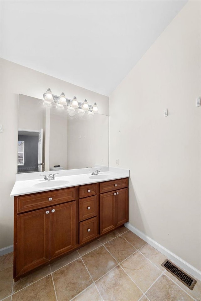 bathroom featuring vanity, tile patterned flooring, and vaulted ceiling