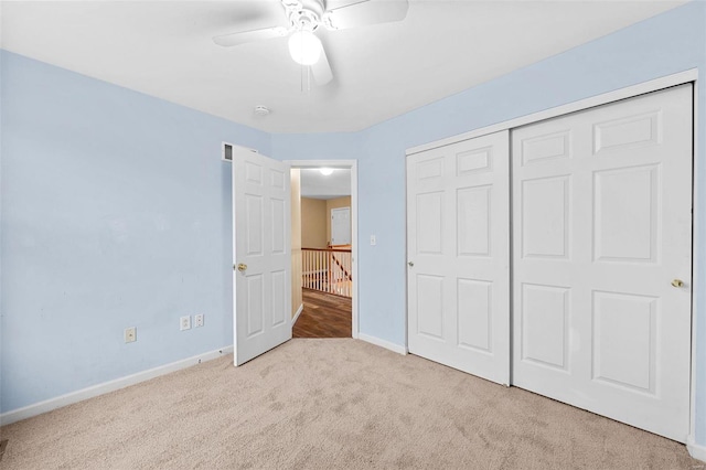 unfurnished bedroom with ceiling fan, a closet, and light carpet