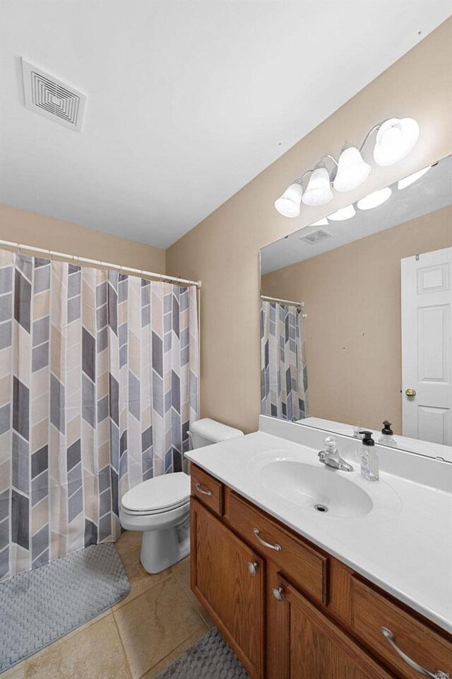 bathroom featuring vanity, tile patterned flooring, and toilet