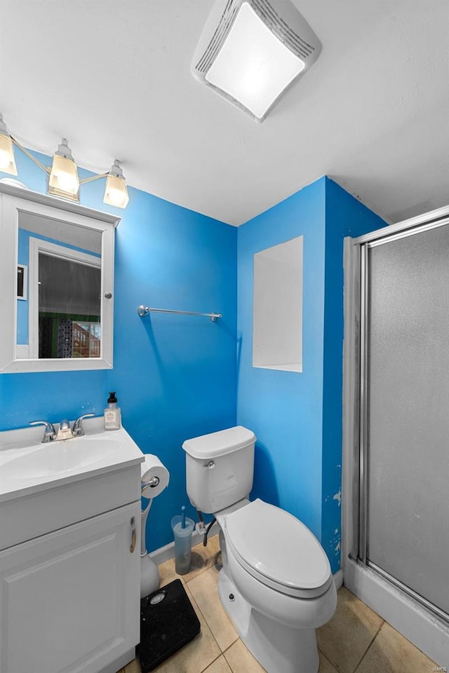 bathroom with tile patterned floors, toilet, a shower with shower door, and vanity