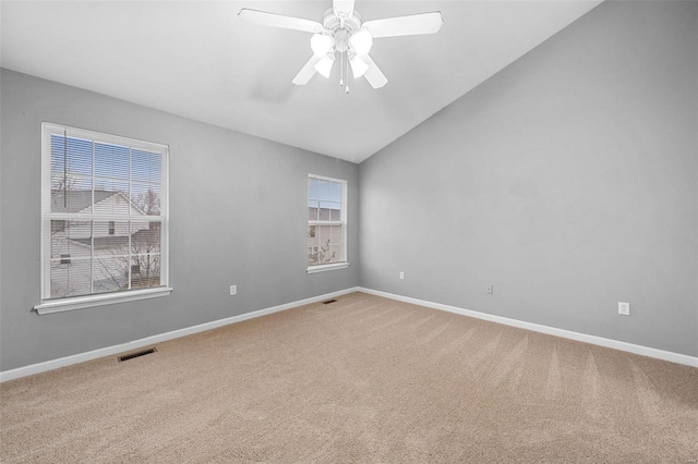 unfurnished room featuring ceiling fan, a healthy amount of sunlight, lofted ceiling, and carpet