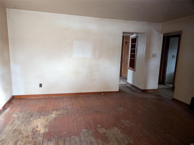 unfurnished room with dark hardwood / wood-style flooring