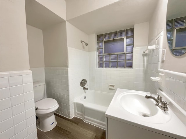 full bathroom with toilet, tub / shower combination, tile walls, vanity, and hardwood / wood-style flooring