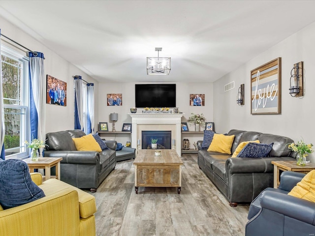 living room featuring an inviting chandelier and light hardwood / wood-style floors