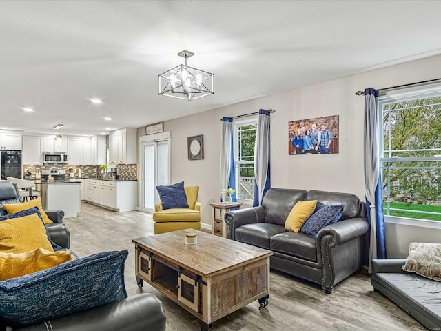 living room with an inviting chandelier and light hardwood / wood-style floors