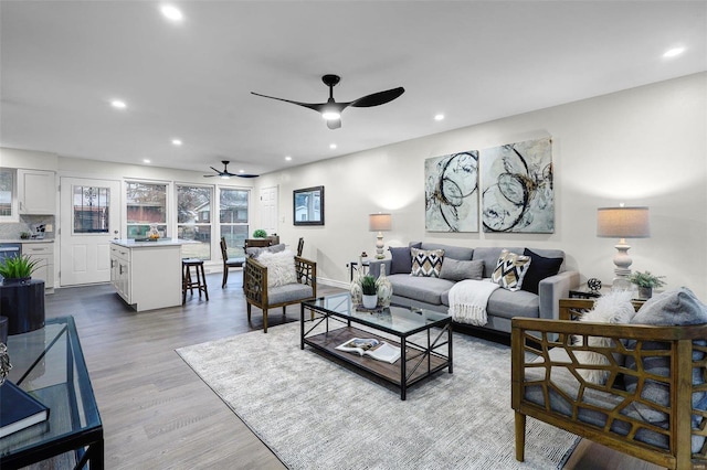 living room with ceiling fan and light wood-type flooring