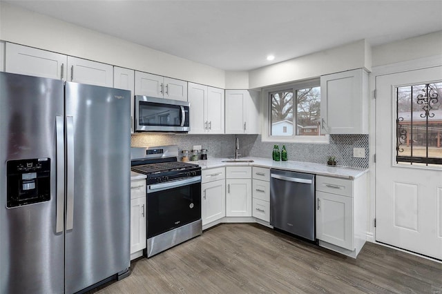 kitchen featuring appliances with stainless steel finishes, sink, white cabinets, and dark hardwood / wood-style flooring