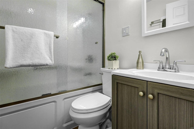 full bathroom with enclosed tub / shower combo, vanity, and toilet