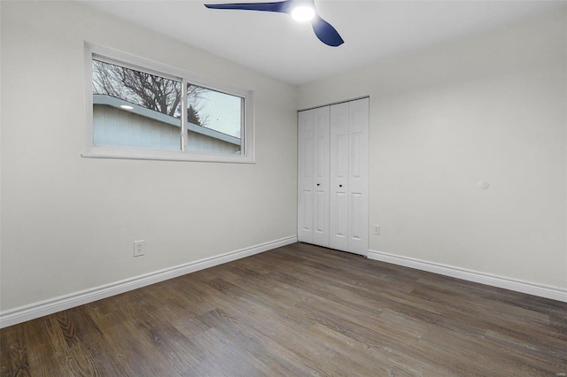 unfurnished bedroom with dark wood-type flooring, ceiling fan, and a closet