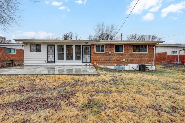 rear view of property with a patio area, central air condition unit, and a lawn