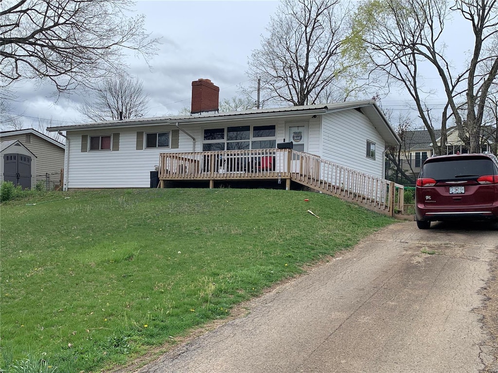 view of front of property with a wooden deck and a front lawn