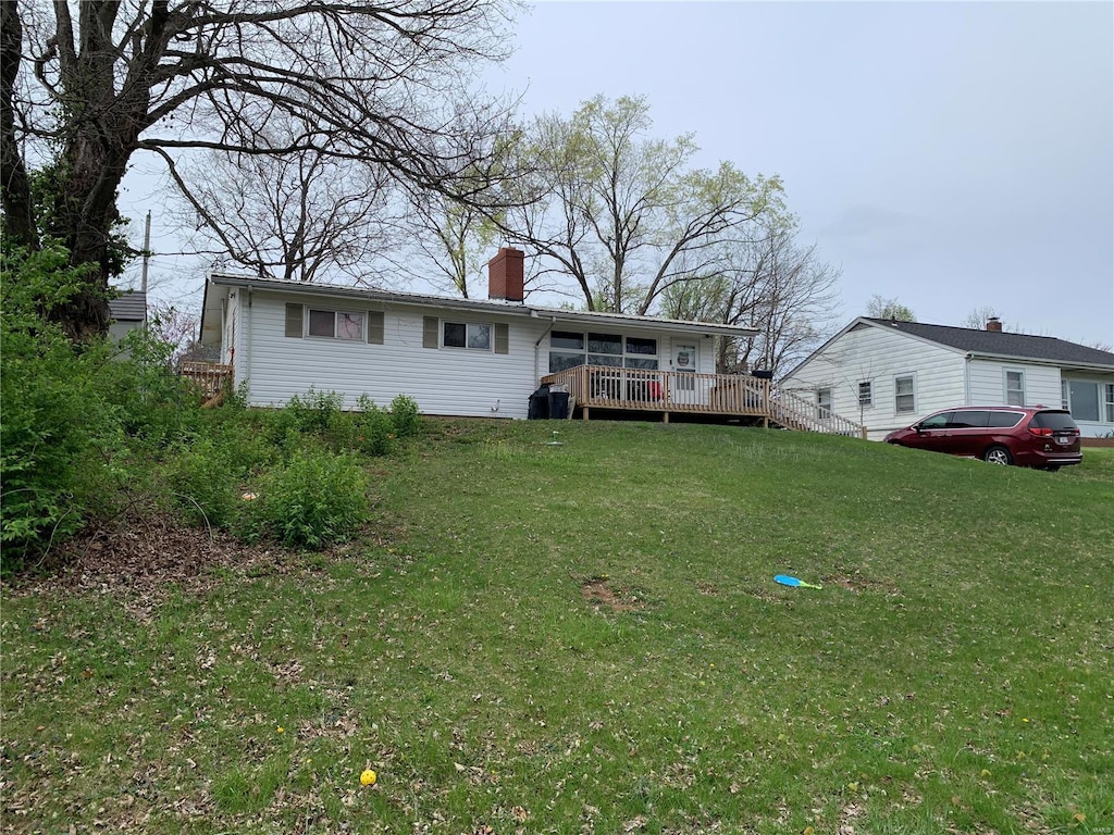 view of front of house featuring a front lawn and a deck