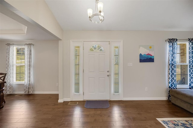 entryway with an inviting chandelier and dark hardwood / wood-style flooring