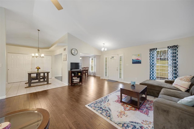 living room with vaulted ceiling, a notable chandelier, and light hardwood / wood-style floors