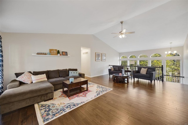 living room with ceiling fan with notable chandelier, high vaulted ceiling, and hardwood / wood-style floors