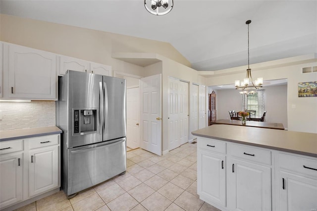 kitchen featuring white cabinetry, lofted ceiling, backsplash, hanging light fixtures, and stainless steel fridge with ice dispenser