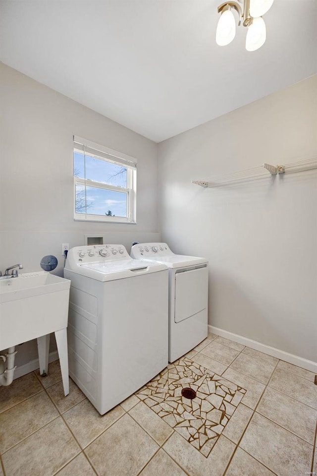 laundry room with light tile patterned flooring, separate washer and dryer, and sink